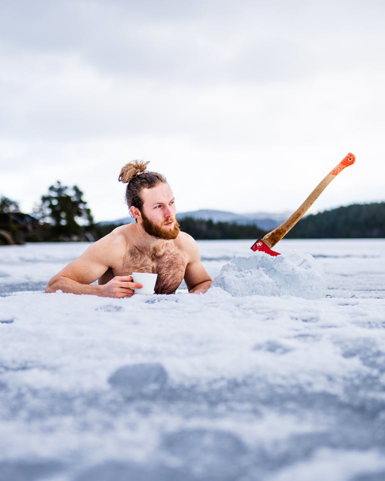 Man Standing in the Frozen River and Holding a Disposable Cup