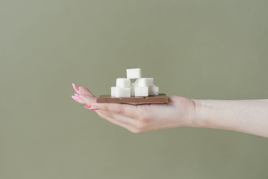 Chocolate Bar and Sugar Cubes on a Hand