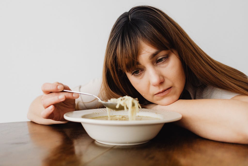 Close-up of a Sad Woman Eating Soup